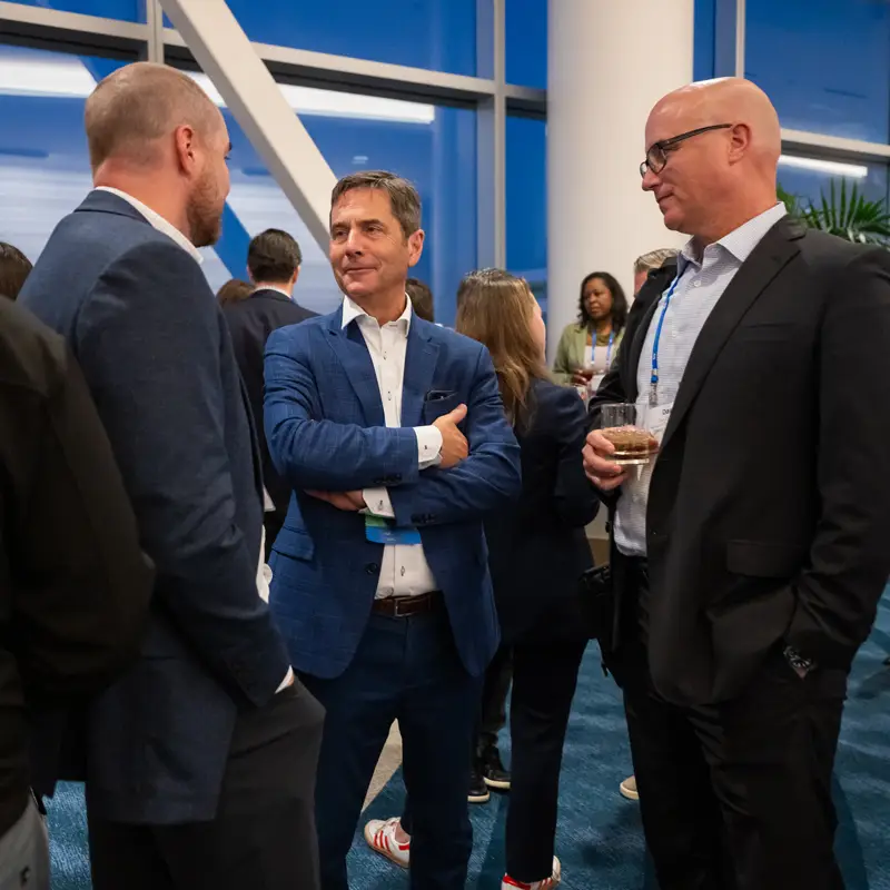 A group of attendees talk during a break